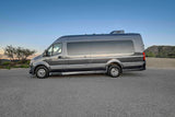 This sleek grey Sprinter camper van rv rental is parked in a scenic desert landscape, perfect for your next adventure.