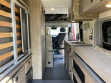 Explore this RV rental's clever interior: functional kitchen, convertible bed, & ample storage for your journey.