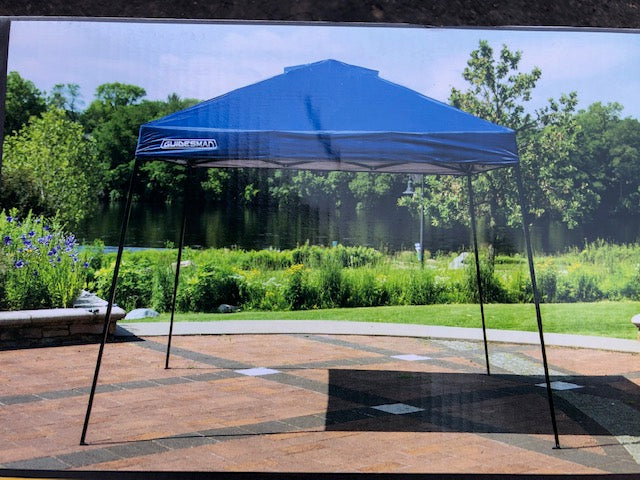 Blue pop-up canopy for outdoor shade, perfect for RV rental camping trips. Provides portable shelter on a sunny patio by the water.