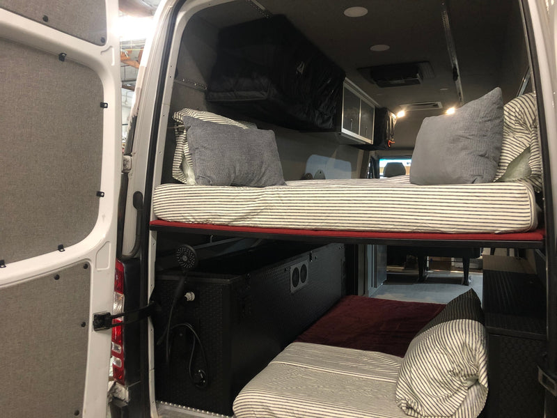 RV rental camper van interior with clever bunk beds, overhead storage, and a built-in shower, optimizing mobile living space. — photo 9