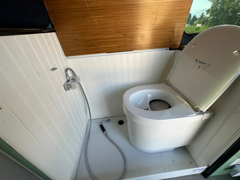 This RV rental offers a practical bathroom with a Separett composting toilet and a flexible shower setup. — photo 13