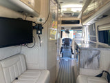 Explore this modern RV rental interior featuring a galley kitchen, TV, and comfortable seating. Ideal for your next adventure.
