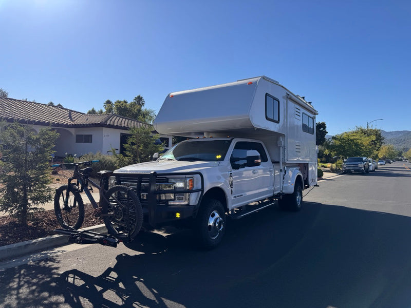 mountains in the distance.|Adventure-ready RV rental: White Ford truck camper with a mountain bike — photo 2