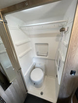 RV rental interior: A compact wet bath with shower, toilet, and integrated storage, designed for efficiency.