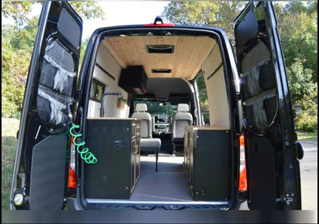 Inside a black RV rental van: custom wood ceiling, sleek black cabinets, and organized storage for adventures.