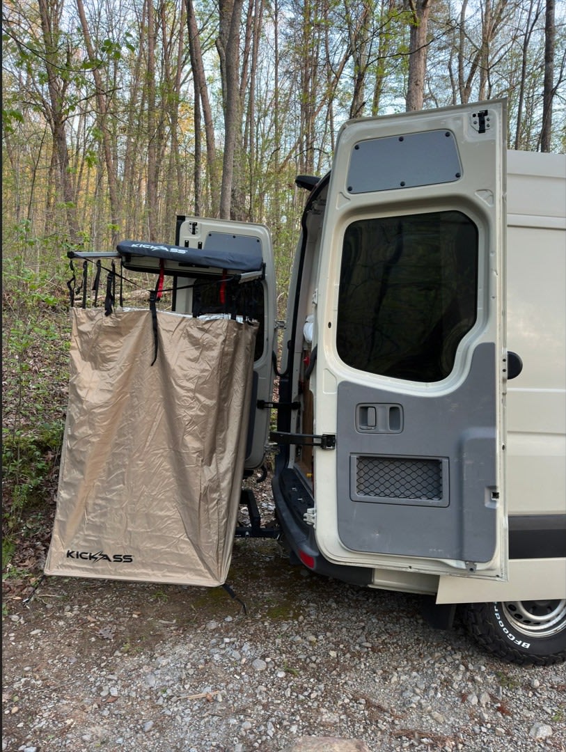 RV rental camper van with an outdoor KICKASS privacy shower attached to its open rear door, set in a peaceful forest for van life adventures. — photo 8