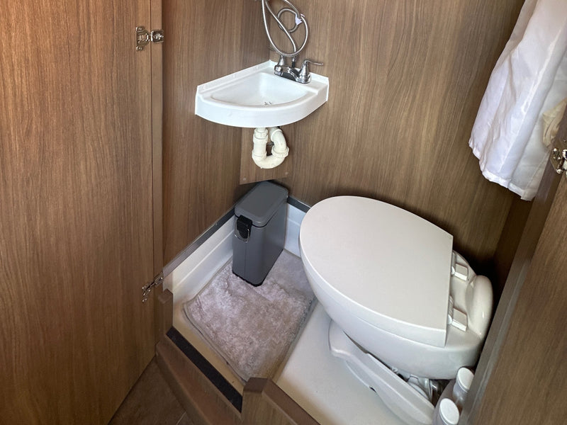  showing side profile with tinted windows & awning.|Relax in this **rv rental**'s inviting bed — photo 5