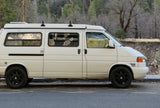 White RV rental campervan parked roadside, ready for adventure in a tranquil winter forest setting.