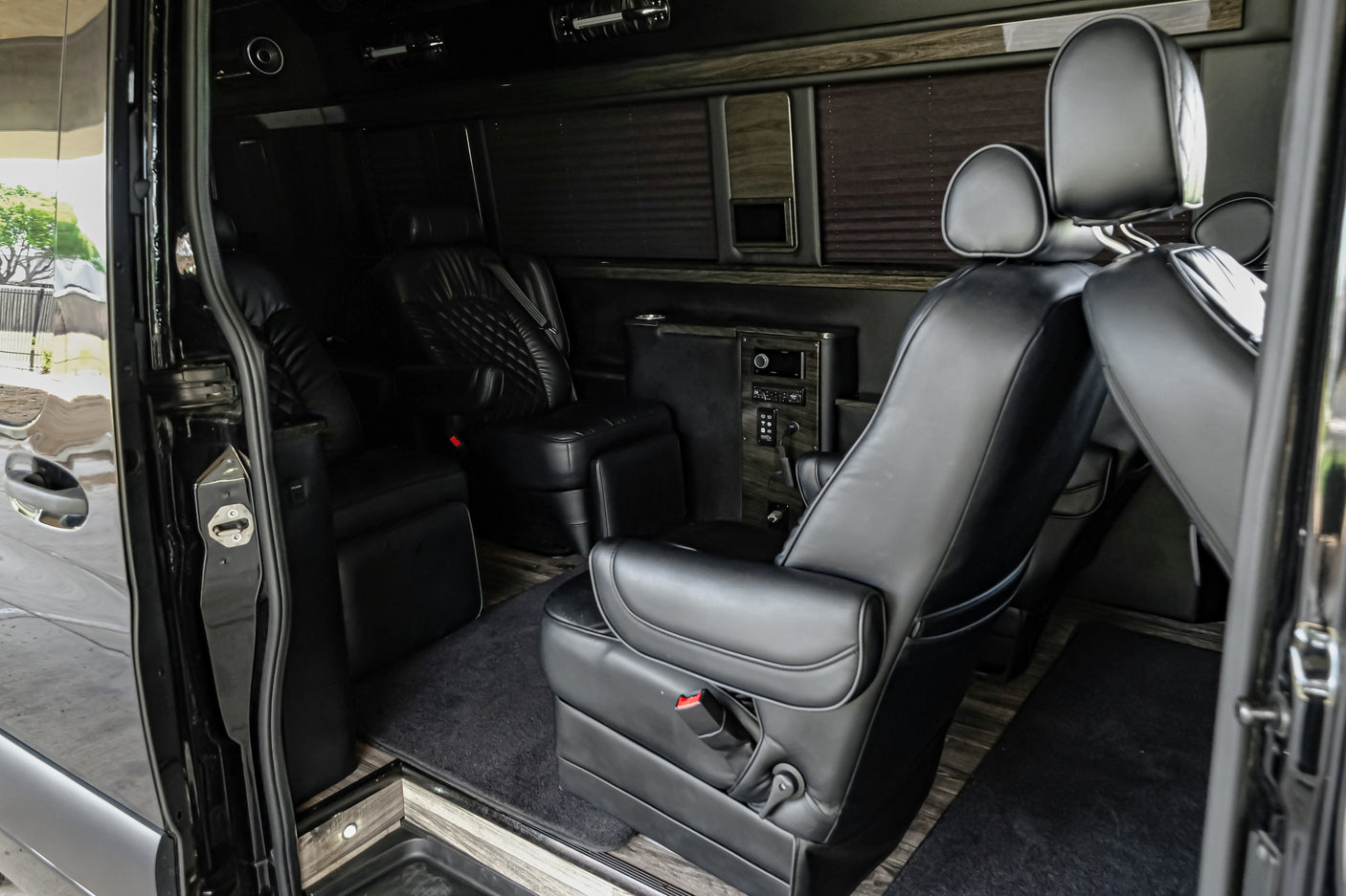 Experience comfort in this RV rental: luxurious black leather interior, captain's chairs, wood paneling & controls.