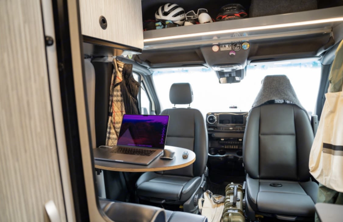  overlooks a picturesque frozen lake and majestic snow-capped mountains.|Cozy rv rental interior: a comfortable bed with a quilted blanket and pillow — photo 6
