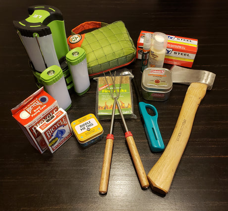 Prepping for an RV rental adventure: camping gear like lanterns, an axe, first-aid, bug spray, fire starters, and games.
