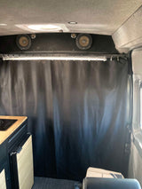 RV rental: Inside a camper van with premium speakers, a privacy curtain, and a compact kitchenette.