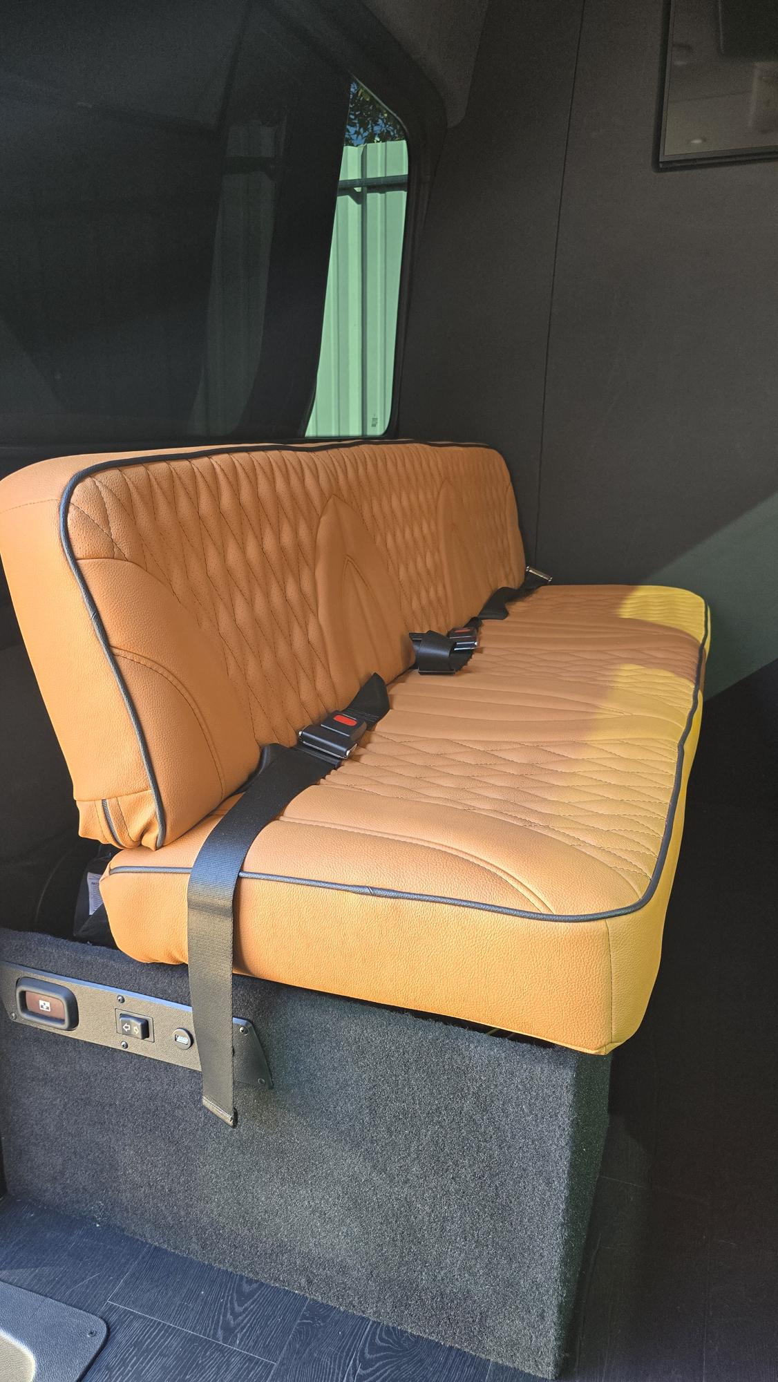  and integrated amenities for premium travel.|Luxury RV rental interior: tan quilted captain seats — photo 8