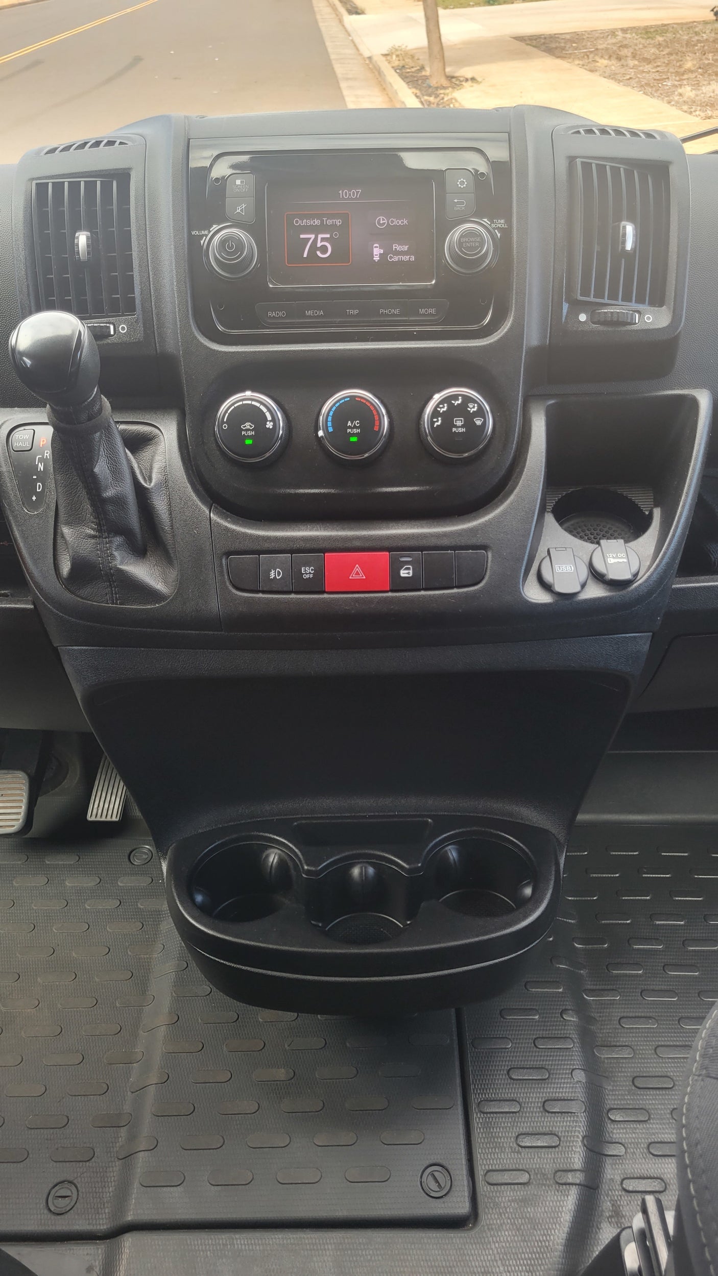 View inside an **RV rental** showing the dashboard with a 75° temperature display, gear shift, and USB ports.